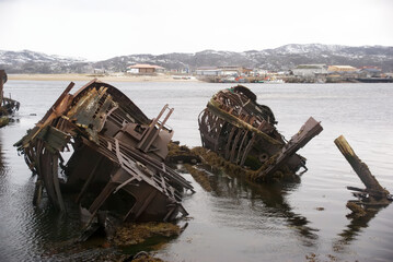 The Arctic Ocean and a northern city with old shipwrecks