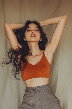 A photograph of an Asian woman wearing her hair in loose waves with one side behind her shoulder, showcasing it to its best effect