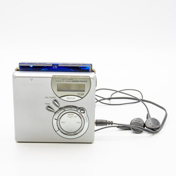Close-up of a minidisc player and recorder with headphones and a minidisc disc isolated on white background