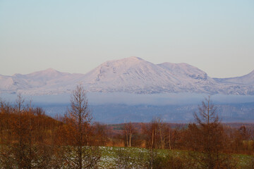 秋の夕暮れの十勝岳と紅葉風景