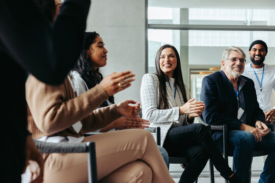 Interactive corporate dialogue: Diverse professionals engaged in discussion and applause