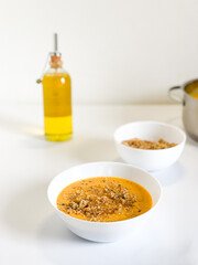 Indulge in the Delightful Creamy Pumpkin Soup, Topped with Garnishes and Drizzled with Olive Oil