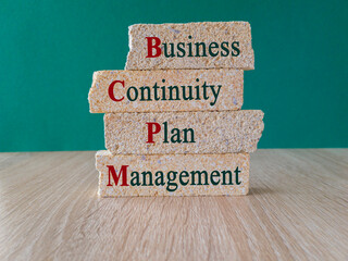 BCPM symbol. Concept words BCPM Business Continuity Plan Management on brick blocks. Beautiful green background, wooden table. Business concept.
