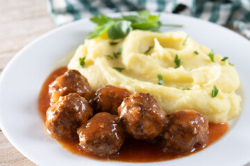 Meatballs with mashed potatoes on wooden table