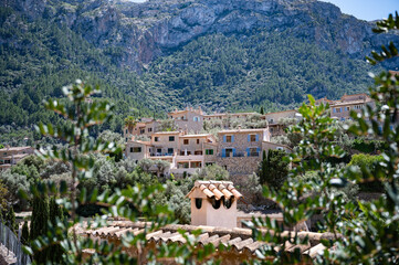 Deia, Mallorca mountain village cityscape with real estate on a hill, mountain range, majorca spain