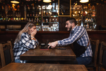 Bartender life. Two young bartenders argue about coffee taste and shifts in the workplace. Employees waiters in the bar, mad and woman, fight and misunderstanding, jealousy about tip and earnings.