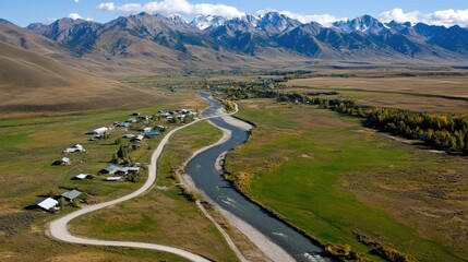 Fototapeta premium Aerial View of Winding River Through Mountain Valley in Autumn