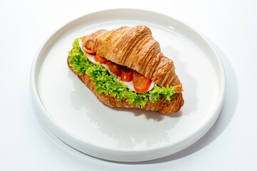 croissants stuffed with ham and vegetables on a white background