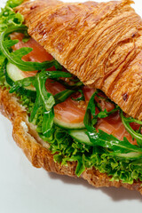 croissants stuffed with ham and vegetables on a white background
