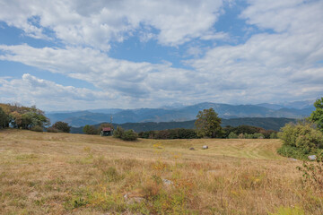 ampia vista panoramica su un ambiente naturale tra le colline e le montagne della Slovenia occidentale, di pomeriggio, in estate