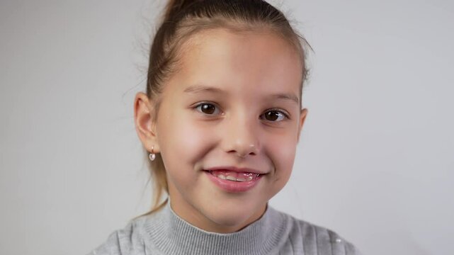 Girl with dental braces or teeth retainers for teeth correction. Pretty girl wearing braces smiling, looking at camera, close-up.