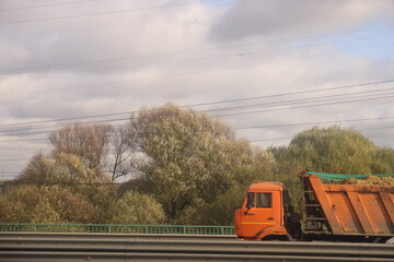 A truck moves along the highway against the background of metal fences in the Moscow region, autumn, October 2024, 2