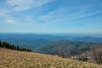 ampia vista panoramica dai pendii erbosi del monte matajur verso la vasta area collinare e montana sul confine tra Italia e Slovenia, di mattina, in primavera