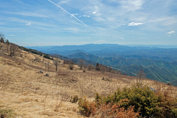 ampia vista panoramica dai pendii erbosi del monte matajur verso la vasta area collinare e montana sul confine tra Italia e Slovenia, di mattina, in primavera