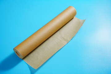 A roll of baking paper on a blue background. tools for baking at home.