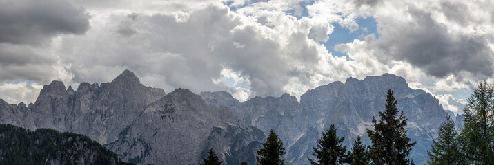 dettaglio sulle alte cime di una catena montuosa alpina in Friuli Venezia Giulia, nell'Italia nord orientale, di giorno, in estate, con un cielo coperto da grosse nubi © PhotoMet