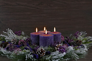 Dekoration zum vierten Advent: Adventskranz mit lila Kerzen.