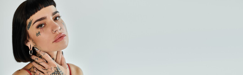 Obraz premium Tattooed woman showcases her fashion sense with a bold look.