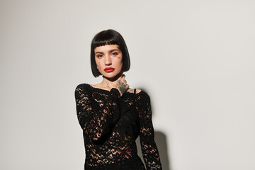 Trendy woman showcases confidence with tattoos and stylish attire.