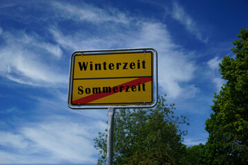 Schild mit der Aufschrift Sommerzeit durchgestrichen und Winterzeit 