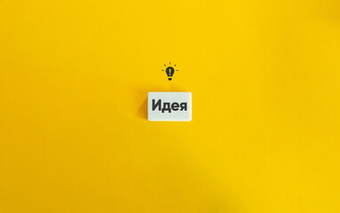 Idea Word and Conceptual Image. Bulb Icon and Text on Block Letter Tile on Yellow Background....