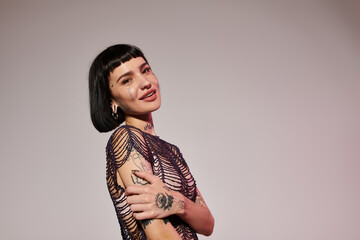 A fashionable young woman with tattoos showcases her unique style confidently.