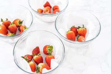 Fresh and Moldy Strawberries in a Glass Bowl on a White Napkin