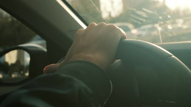 Man driving car. Driver's hand on steering wheel against the background of road. Elegant male driver traveling by car