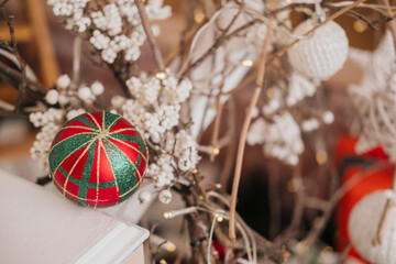 Colorful Christmas ornament on a decorated festive branch with lights