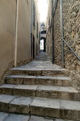 Obraz premium Narrow Stone Alleyway in Historic European Town for Architectural Prints and Travel Posters