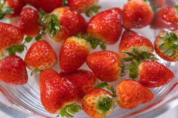 Preparing Strawberries in a Glass Mixing Bowl with Water