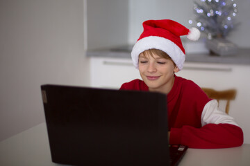 Boy in Santa Hat Video Calling Next to Laptop