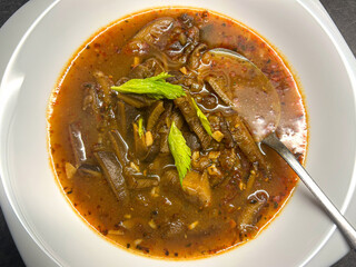 Top view shot of oyster mushroom soup with vegetables and green leaf