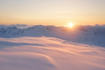 Sunrise over snow-covered mountains in serene winter landscape