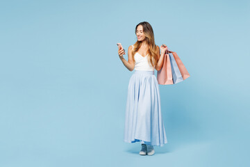 Full body young woman wears casual clothes hold in hand paper package bags after shopping use...