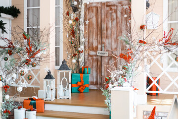 Festive holiday decorations at a cozy home entrance with gifts and greenery