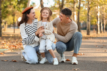 Fototapeta premium Happy family sitting in beautiful autumn park