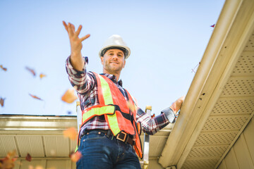 man with hard hat standing on steps inspecting house roof