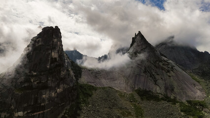 the rocks in the form of a parabola are shrouded in white clouds