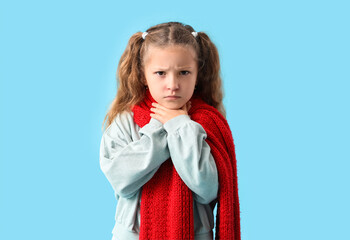 Sick little girl with sore throat on blue background