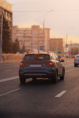 Autumn landscape and view of the road with cars. Orange evening sun and reflections on cars.