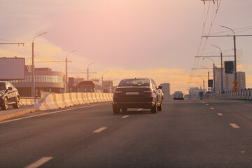 Autumn landscape and view of the road with cars. Orange evening sun and reflections on cars.