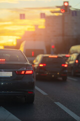 Autumn landscape and view of the road with cars. Orange evening sun and reflections on cars.
