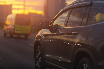 Fototapeta premium Autumn landscape and view of the road with cars. Orange evening sun and reflections on cars.