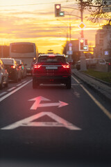 Autumn landscape and view of the road with cars. Orange evening sun and reflections on cars.