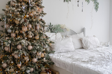 Cozy bedroom corner decorated with a festive Christmas tree and snowflakes