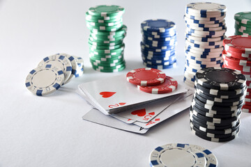 Deck of cards and stacks of chips on white table