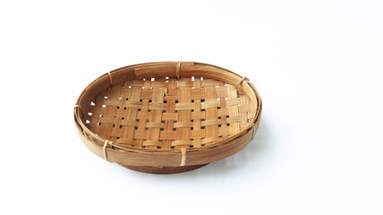 Traditional wicker plate made of bamboo isolated on a white background. Copy space. 45 degree angle setup