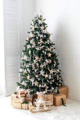 Elegant Christmas tree adorned with ornaments and wrapped gifts in a cozy room