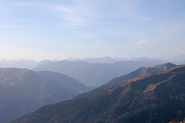 vista panoramica, in alta quota, su di un ambiente naturale di montagna nel nord Italia con tante catene montuose che si estendono verso l'orizzonte, di giorno, in autunno, avvolto dalla foschia